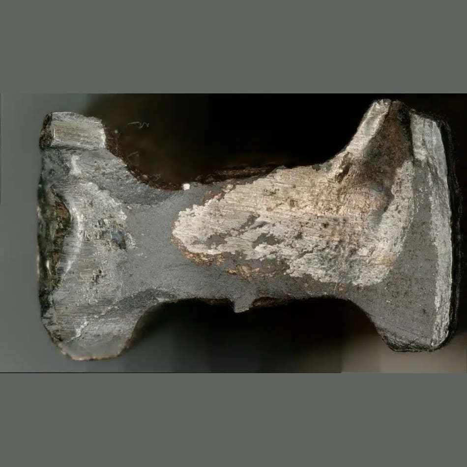 Makroaufnahme der Bruchfläche eines Metallbauteils mit Riefen, Abrieb und Korrosionsspuren